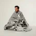 Persona envuelta en manta térmica de emergencia Mylar